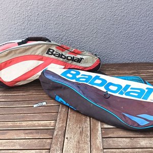 Dos bolsos o fundas para raquetas de tenis marca Babolat, de diferentes modelos y colores, con cierres; usados, con desgaste y señales de uso visibles. - imagen 1