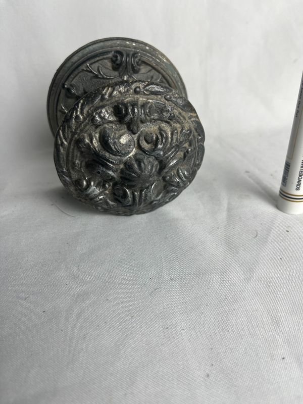 Lote siguiente: Manotón de bronce: Un objeto de metal con diseños intrincados