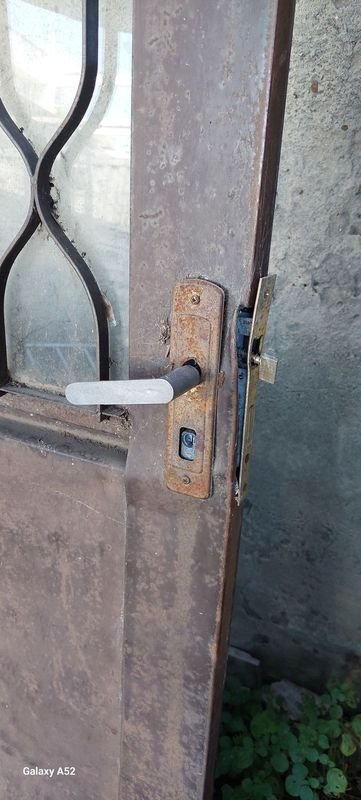 Puerta de madera con ventana y candado - imagen 2