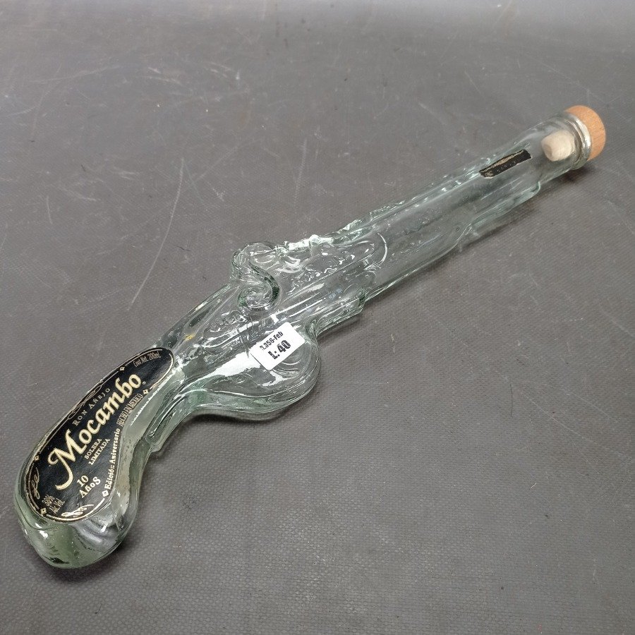 Lote siguiente: Botella de ron con forma de pistola y etiqueta con diseño ornamental