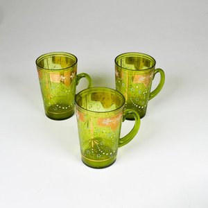 Lote siguiente: Tres jarritos de vidrio y esmalte con asas, alturas 11 cm
