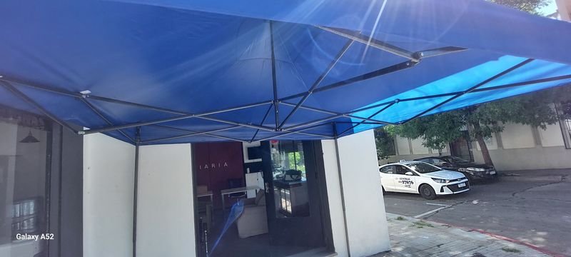Tenda azul y vehículos en un entorno urbano - imagen 4