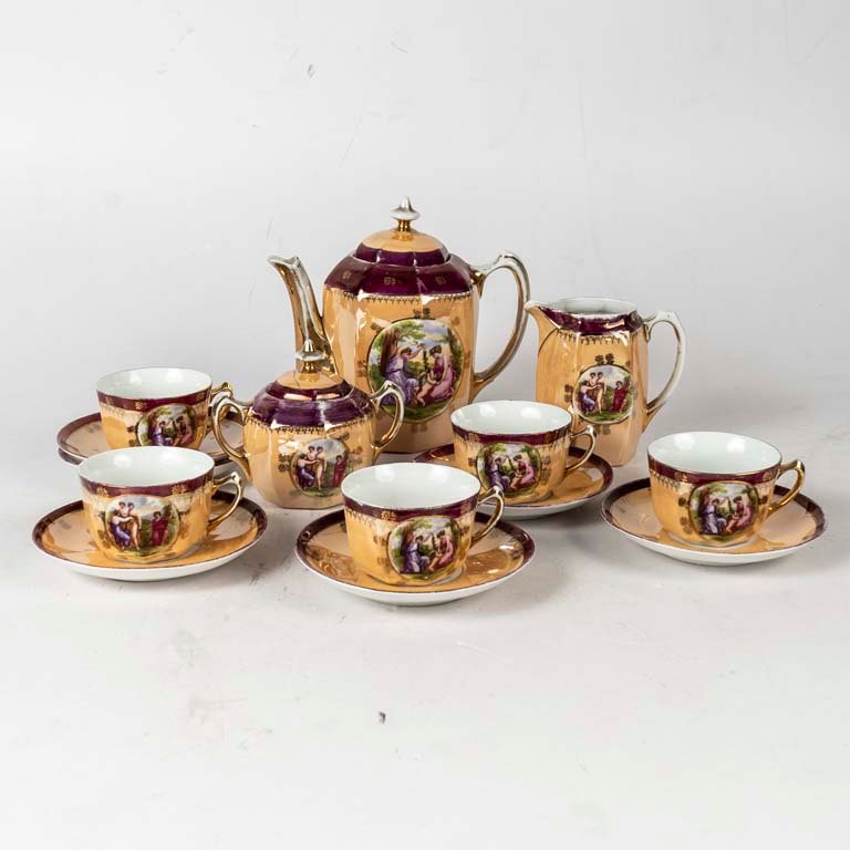 14 Piezas de té de porcelana, con escena. Tapa de la azucarera con avería. Meidas: 8.5x 5 cm