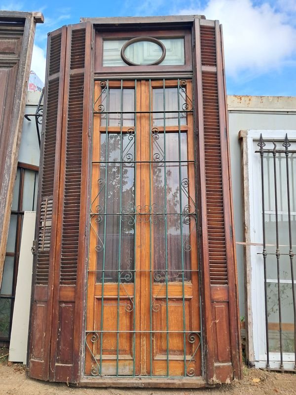 Lote siguiente: Puerta antigua de madera con postigos y reja