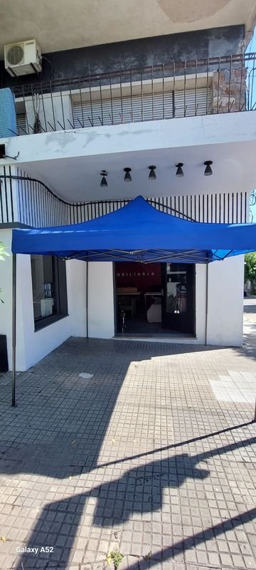 Tenda azul y vehículos en un entorno urbano - imagen 3