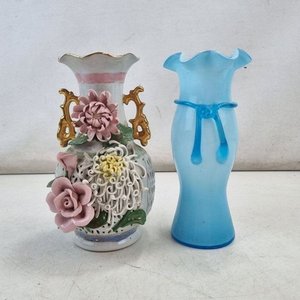 Lote siguiente: L 061 - 2 Piezas - Par de floreros decorativos, uno en fina porcelana china con relieve floral y calado, y otro en vidrio opalescente color celeste con detalles aplicados