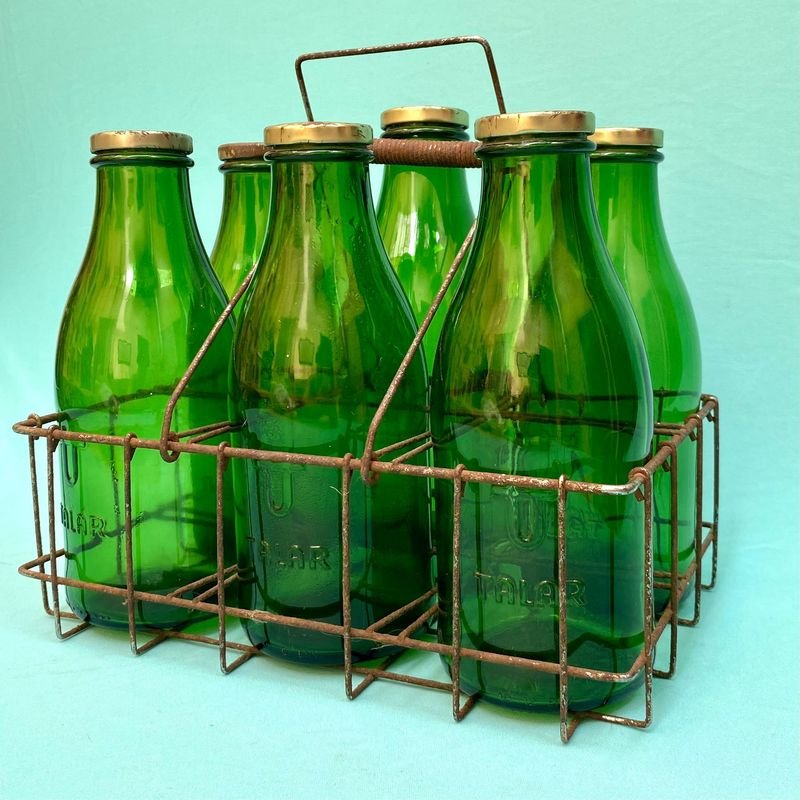 Vendedor de botellas de vidrio verde con tapas metálicas