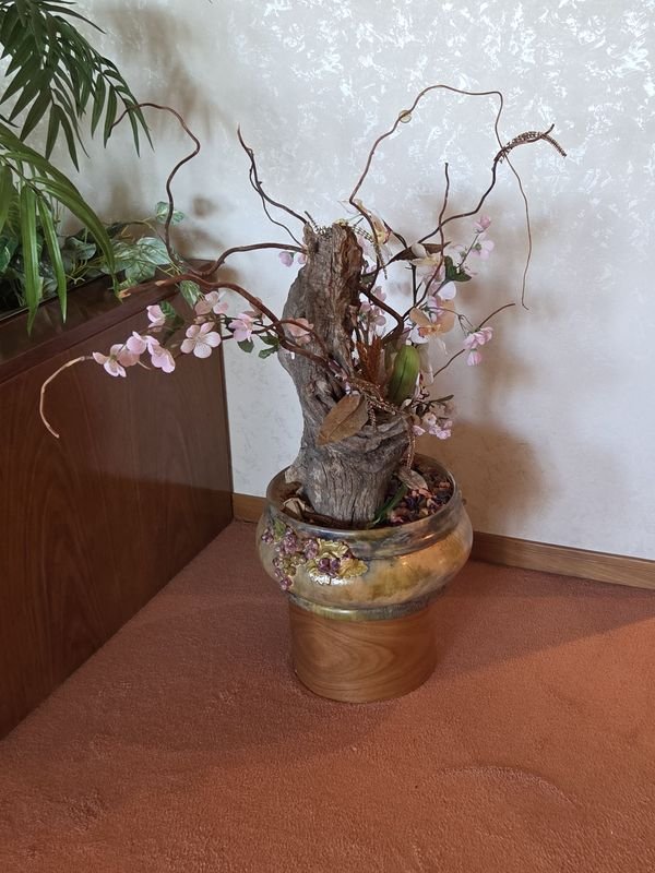 Lote siguiente: Arreglo floral artificial en maceta de cerámica sobre base de madera