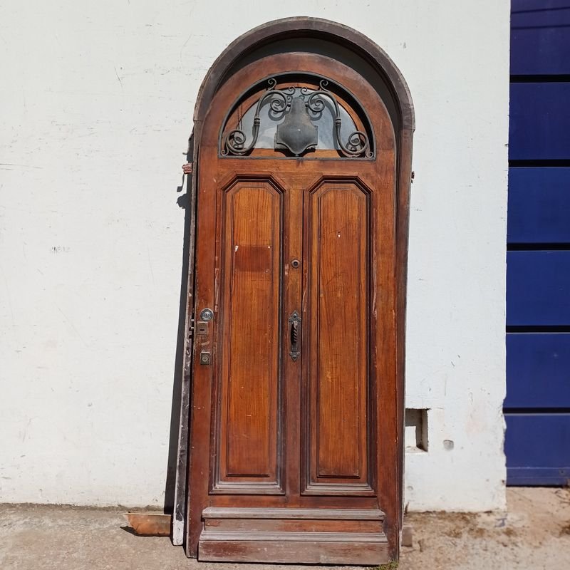 Lote siguiente: Puerta arqueada de cedro con marco y herrajes en hierro forjado