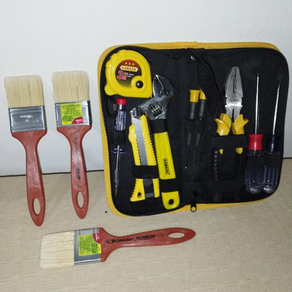 Tres pinceles nuevos de pintura en un bolso amarillo