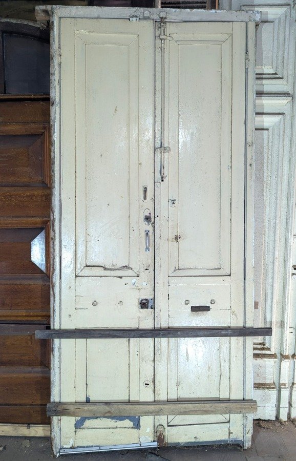 Puerta de dos hojas batientes en cedro con diseño de tablero y manotones de bronce - imagen 3