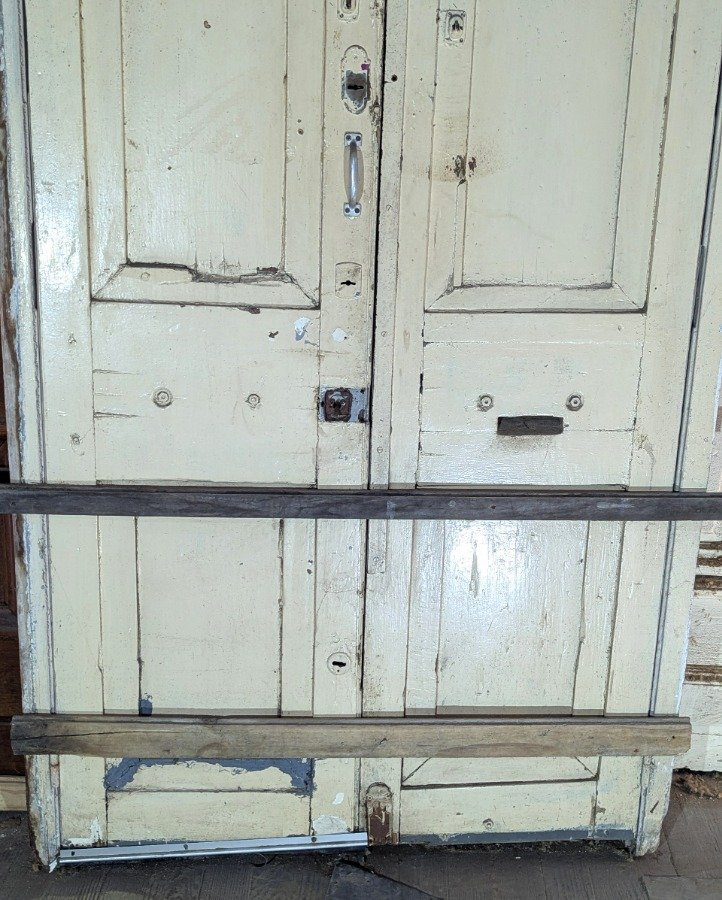 Puerta de dos hojas batientes en cedro con diseño de tablero y manotones de bronce - imagen 11