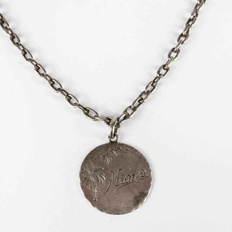 Lote siguiente: Cadena de plata con medalla grabada 'Mamá' - Excelente condición