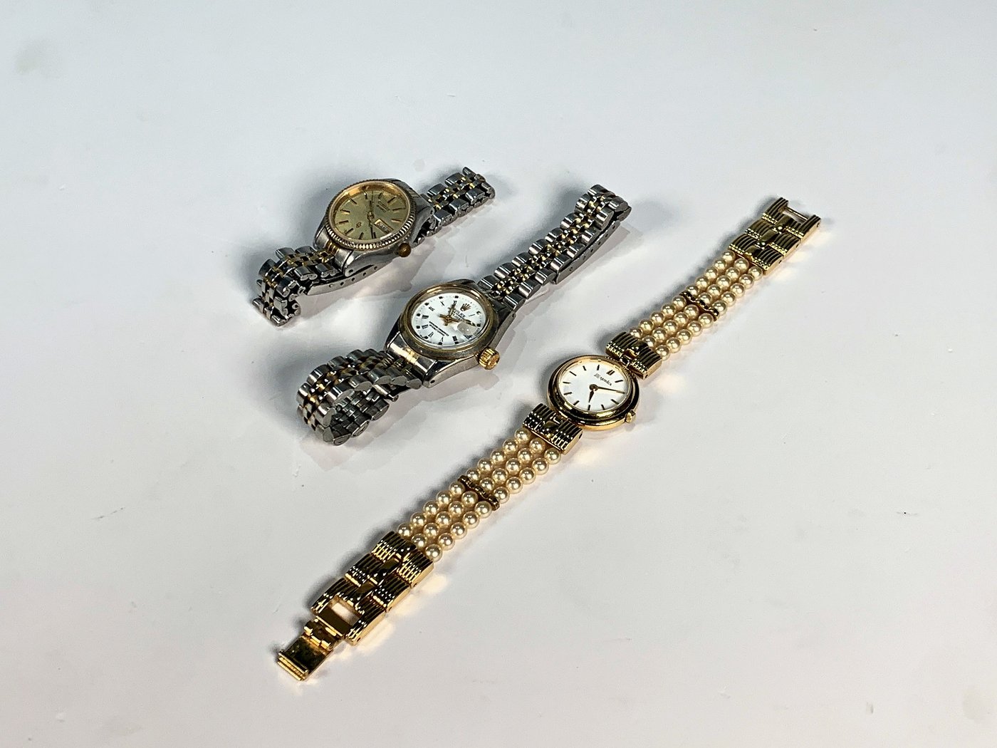 Tres Relojes de Pulsera para Dama: Dorado con Perlas, Dos Plateados y Dorados con Calendario