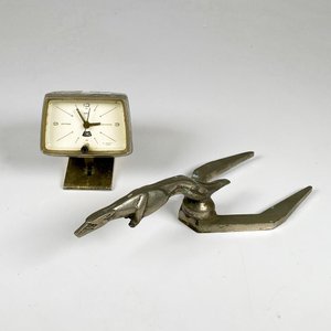 Figura de metal de capot de auto y reloj sobre mesa - imagen 1