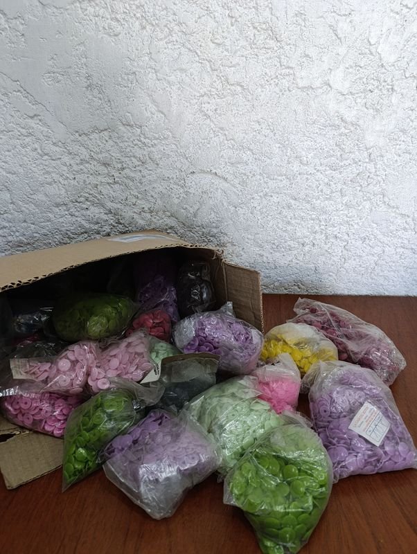 Botones variados en cajas de plástico