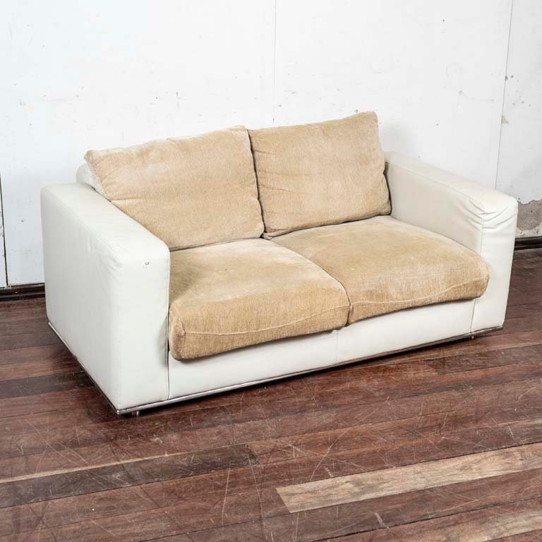 Lote anterior: Sofá de dos cuerpos tapizado en cuerina blanca, almohadones tapizados en pana y patas cromadas
