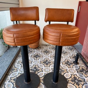 Lote #012B – Dos butacas para barra en caño grueso de amurar al piso, tapizadas en cuero color whisky – 37cm diámetro asiento, 74cm de altura al asiento y 92cm total - imagen 1
