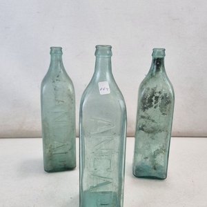 Lote siguiente: L 342 - Lote De 3 Piezas - Lote de antiguas botellas de vidrio en color verdoso, con la inscripción “ANCAP” en relieve