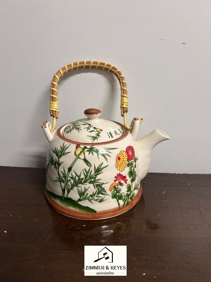 Tetera de cerámica con diseño floral y bambú