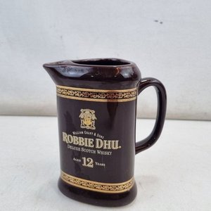 Lote anterior: L 487 - 1 Pieza - Jarra de whisky Robbie Dhu de Castle Ceramics, con motivos en dorado y boca con orificio para dosificador (Medidas 14x11x17cm)
