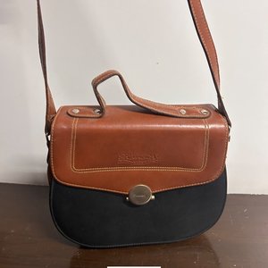 Lote siguiente: Cartera de cuero marrón y negro con detalles dorados