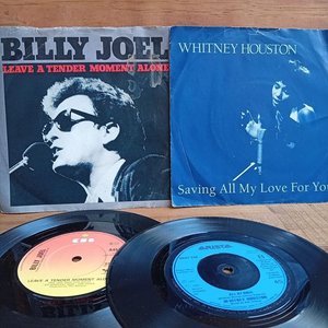 Lote siguiente: Dos discos simples: Billy Joel "Leave a Tender Moment Alone" y Whitney Houston "Saving All My Love For You"