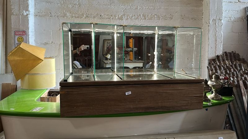 Lote siguiente: Vitrina de Vidrio con Base Madera