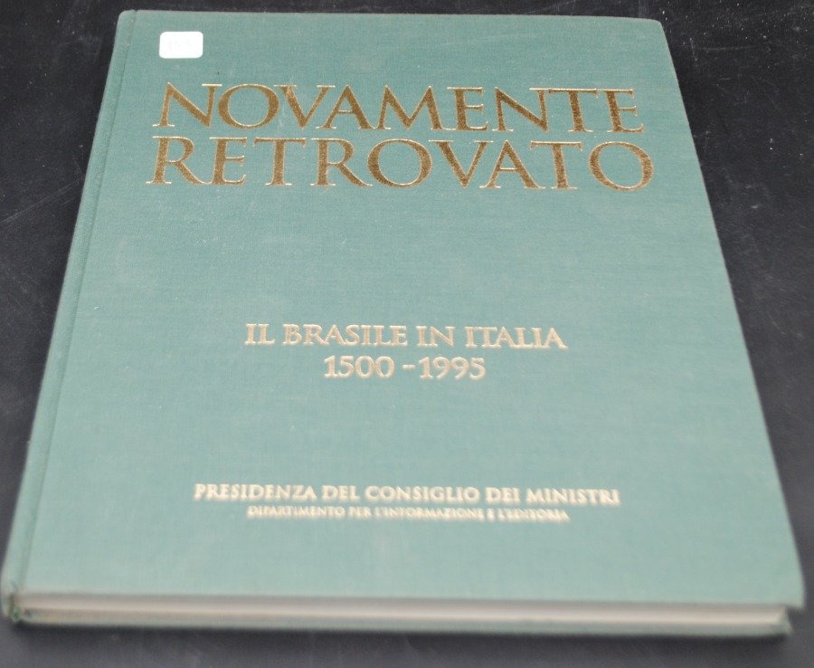 Libro 'NOVAMENTE RETROVATO' con cubierta de tela azul y texto en oro