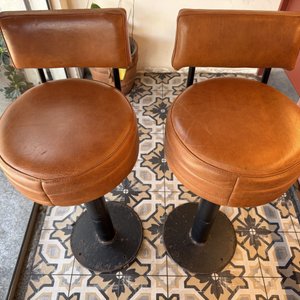 Lote #012D – Dos butacas para barra en caño grueso de amurar al piso, tapizadas en cuero color whisky – 37cm diámetro asiento, 74cm de altura al asiento y 92cm total - imagen 2