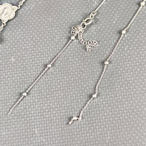 Lote de 4 piezas de joyería: Rosario plateado con detalles a reparar, cadena de plata, pulsera dorada y anillo dorado. - imagen 9