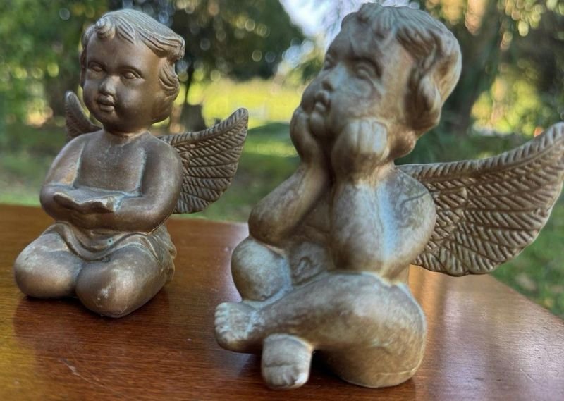 dos querubines en ceramica con un acabado dorado envejesido