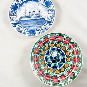 Lote siguiente: Dos platos de cerámica decorativos: uno con buque y otro floral