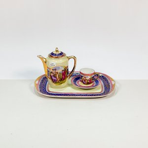 Lote siguiente: Juego de Café de Porcelana Beige con Damas y Guardas Multicolores
