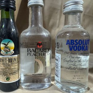 Lote siguiente: Lote de Mini Botellas de Licores Varios: Fernet Branca, Bacardi Peach, Absolut Vodka