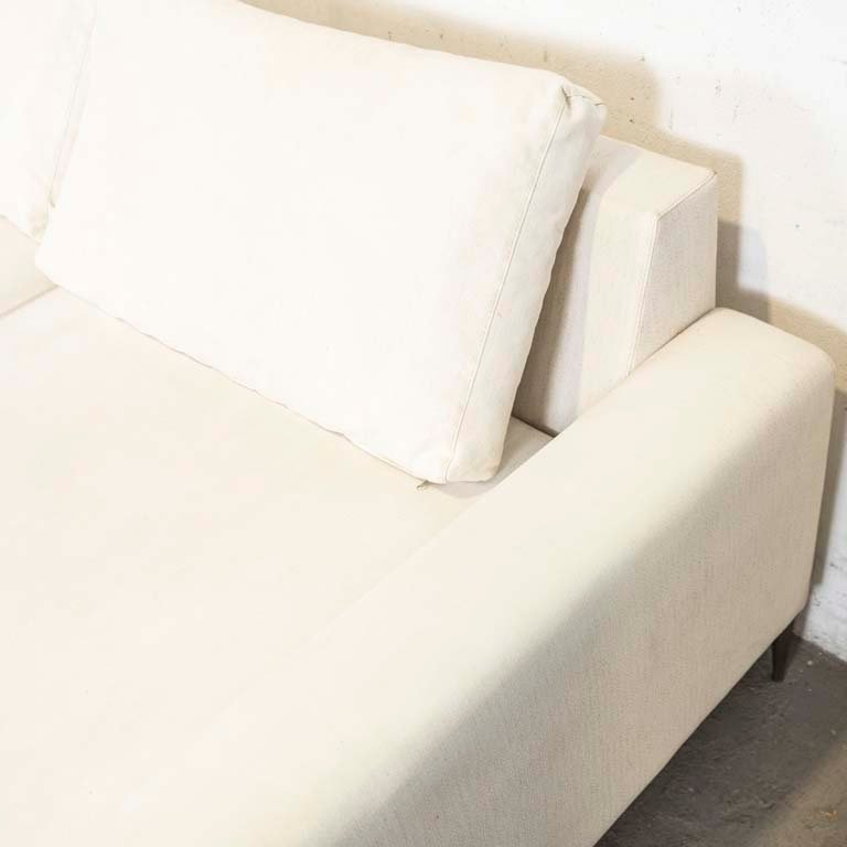 Sofá de dos cuerpos tapizado en tela, con patas metálicas y almohadones en el respaldo - imagen 3