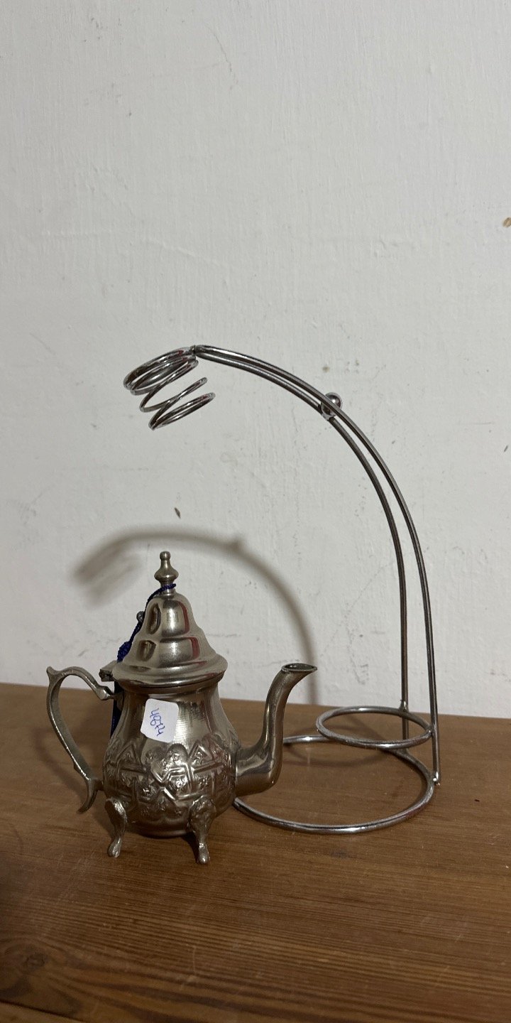 Lote siguiente: Teapot con diseño ornamentado y soporte metálico