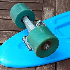 Skate tipo cruiser de plástico color celeste, con cuatro ruedas y ejes metálicos; usado. - imagen 4