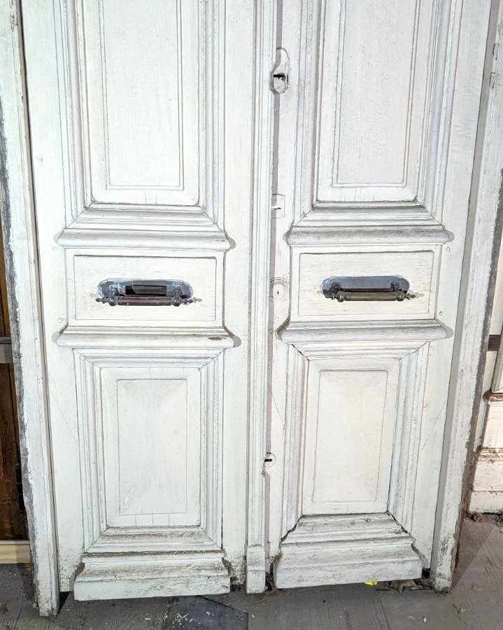 Puerta de dos hojas batientes en cedro con diseño de tablero y manotones de bronce - imagen 4