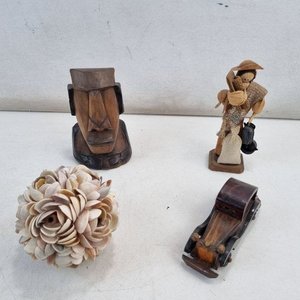 Lote siguiente: Conjunto de 4 Piezas Decorativas: Figura Moai, Hombre con Gorro, Coche de Madera y Adorno Floral