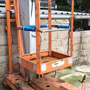 Elevador vertical de personal (Unipersonal) Eléctrico: Plataforma elevadora con canasto de seguridad y panel de control superior. Estructura compacta sobre ruedas, ideal para espacios reducidos en interiores o suelos nivelados - Sin Probar - imagen 1