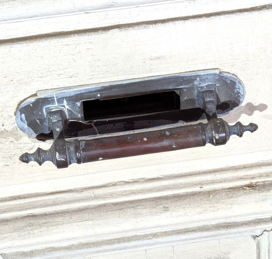 Puerta de dos hojas batientes en cedro con diseño de tablero y manotones de bronce - imagen 7