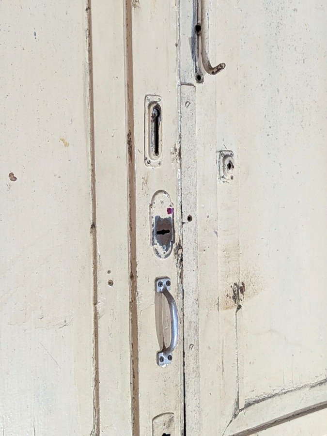 Puerta de dos hojas batientes en cedro con diseño de tablero y manotones de bronce - imagen 13
