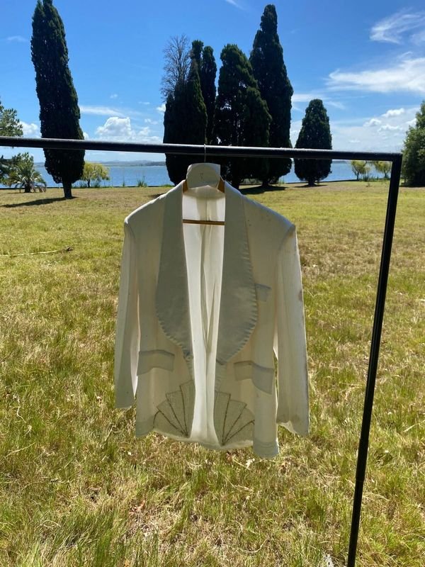 Saco blanco con cuello raso y apliques de alas de mariposas