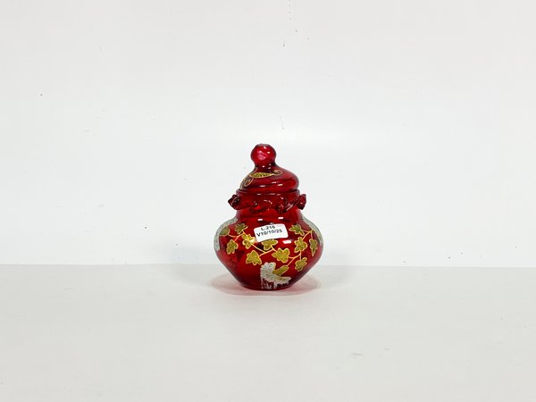 Lote siguiente: Un pote de cristal rubi con decoración floral dorada