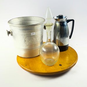 Lote anterior: Cuatro piezas, plato de torta en madera circular, champagnera, botellón hialino y jarra