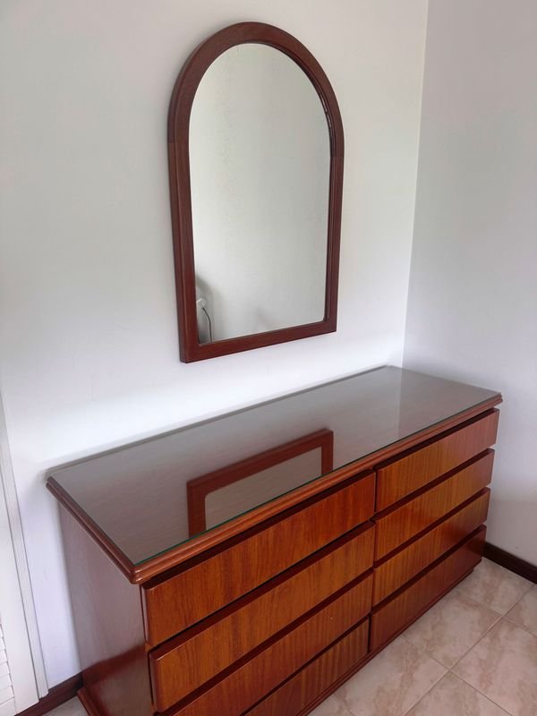 Espejo con marco arqueado y mueble de madera