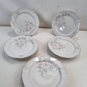 Lote siguiente: L 390 - 11 Piezas - Set de 11 platos de porcelana uruguaya 'Olmos' con diseño de rosas en tonos pasteles y filetes dorados, en atractivo estado