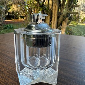 Lote siguiente: ensendedor de mesa vintage con una base de vidrio y mecanismo de ensendido metalico (estilo correspondiente al de los años 70)