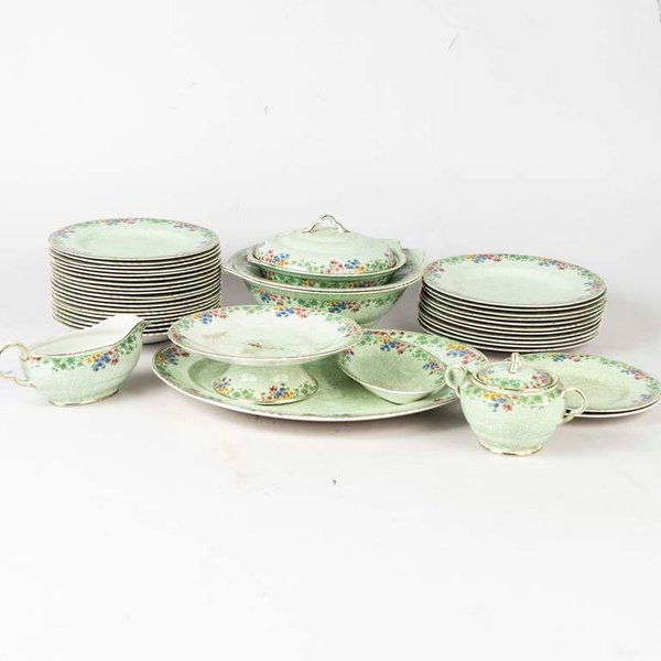 38 Piezas de loza inglesa Fairfield. Diseño flores, fondo verde, borde lobulado dorado. Piezas manchadas, 3 platos con cascaduras y 3 platos con fisuras. Medidas: 20 cm